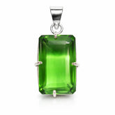 Green gemstone pendant with silver setting on a white background