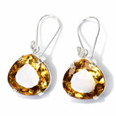Pair of earrings with yellow gemstones on a white background