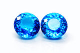 Two blue gemstones on a white background
