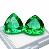Two green gemstones on a white background
