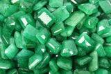 Close-up view of tiny rectangular natural green emeralds, neatly arranged to showcase their consistent shape and vibrant green color.