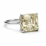 Ring with a square-cut yellow gemstone on a white background