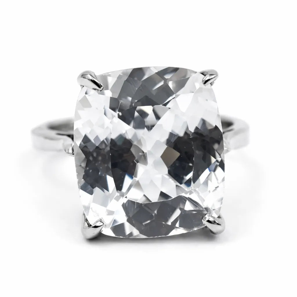 Silver ring with a large, clear gemstone on a white background
