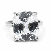 Silver ring with a large, clear gemstone on a white background