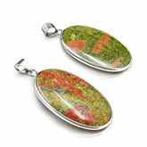 Two stone pendants with silver settings on a white background