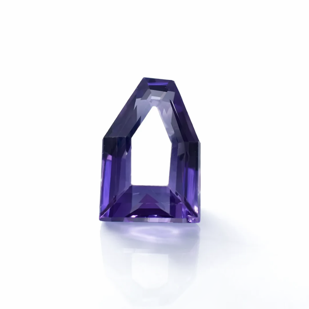Faceted purple gemstone on a white background