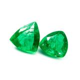 Two green gemstones on a white background