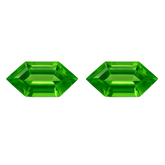 Two green gemstones with a faceted design on a white background