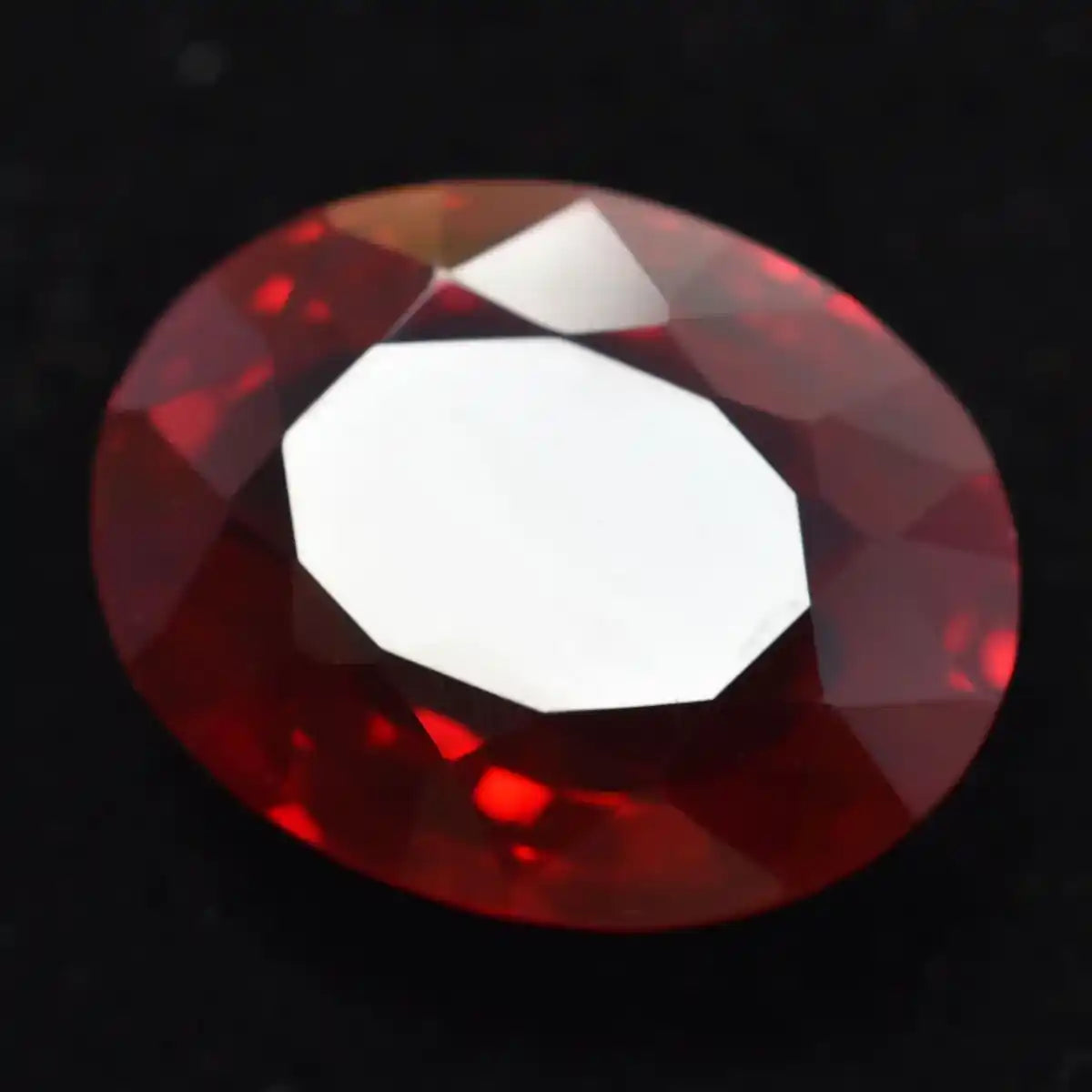 Faceted red gemstone on a black background