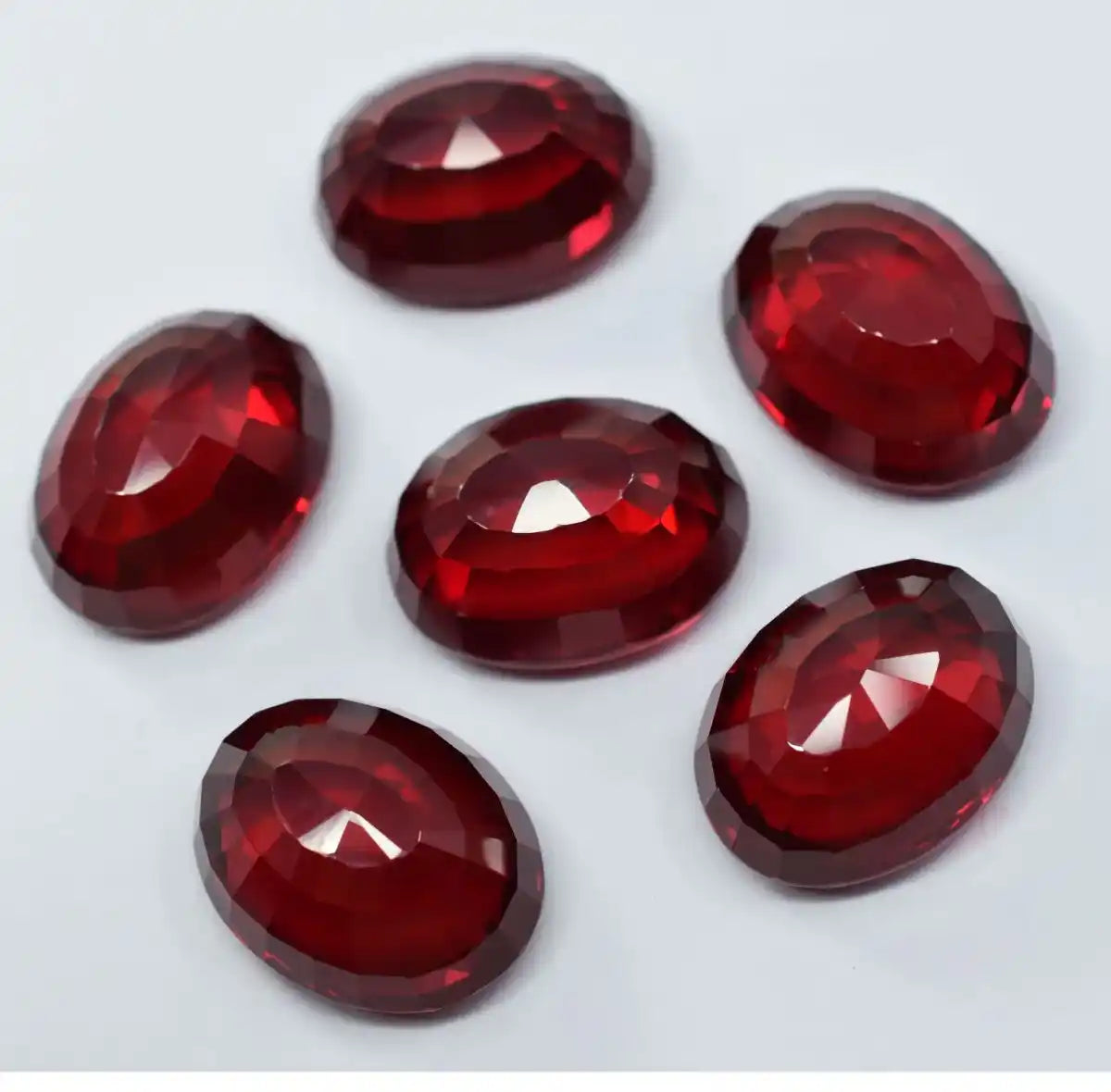 Six red gemstones on a white background