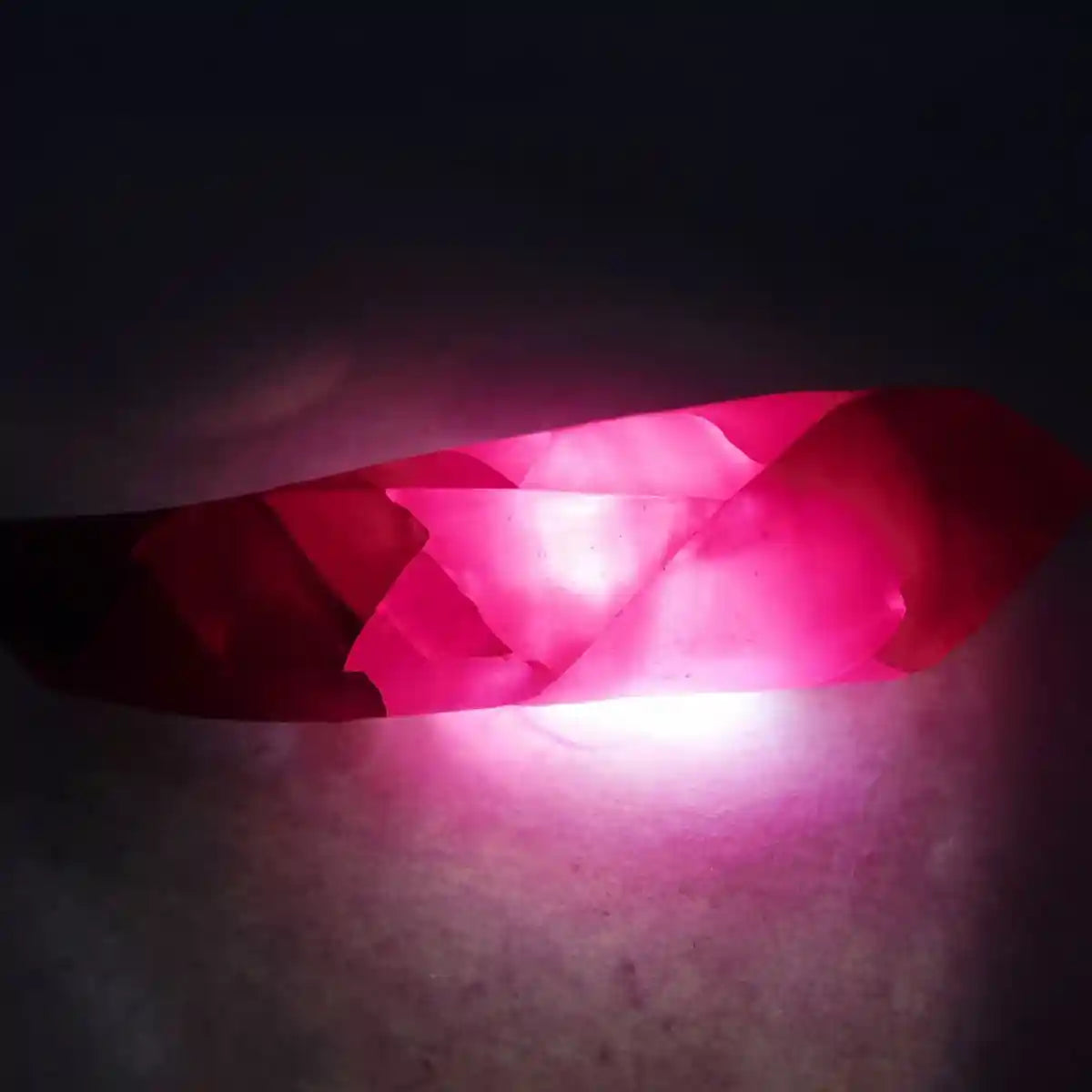 Close-up of a pink crystal with a dark background