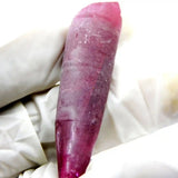 Purple crystal or stone on a white fabric background