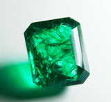Emerald gemstone casting reflection and shadow on white background