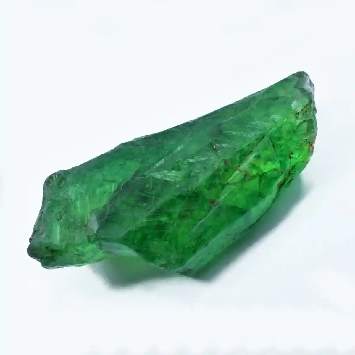 Raw green crystal gemstone rough surface photographed with light reflection