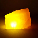 Rectangular salt lamp emitting a warm glow on a dark background