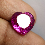 Heart-shaped natural ruby gemstone held between two fingers – 10.30 Ct pink-red certified loose stone