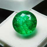 Close-up view of 8.23 carat round Colombian emerald showing its brilliant green hue and clear surface under bright lighting.