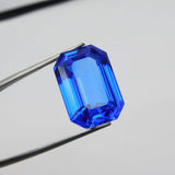 17.60 Ct Natural Blue Tanzanite Emerald Cut Gemstone Held by Juandu Tool – Certified