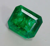 Natural emerald displayed from a side perspective on a white background, emphasizing its translucent body and shape.