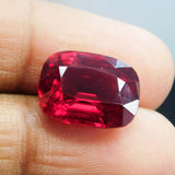 Cushion shaped natural red ruby held between two fingers – 10.10 carat certified loose gemstone