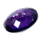 Faceted purple gemstone on a white background