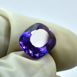 5.60 Carat Natural Tanzanite Gemstone Held in Fingers - Cushion Shape, Purple Color