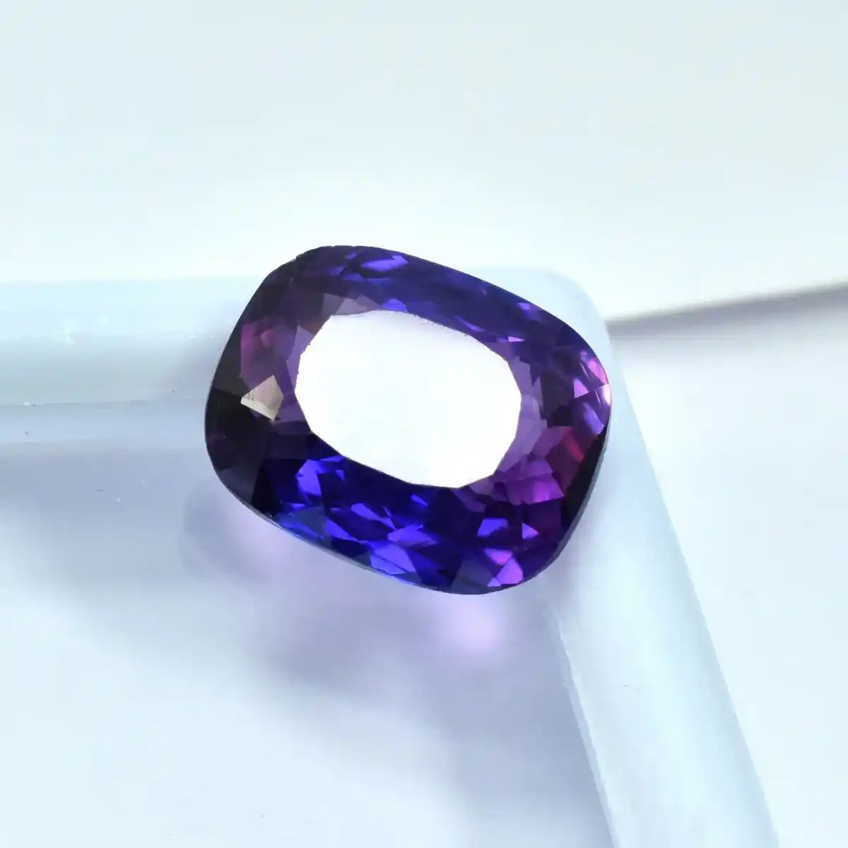 Faceted purple gemstone on a white background
