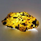 Mineral sample with yellowish glow on a gray background