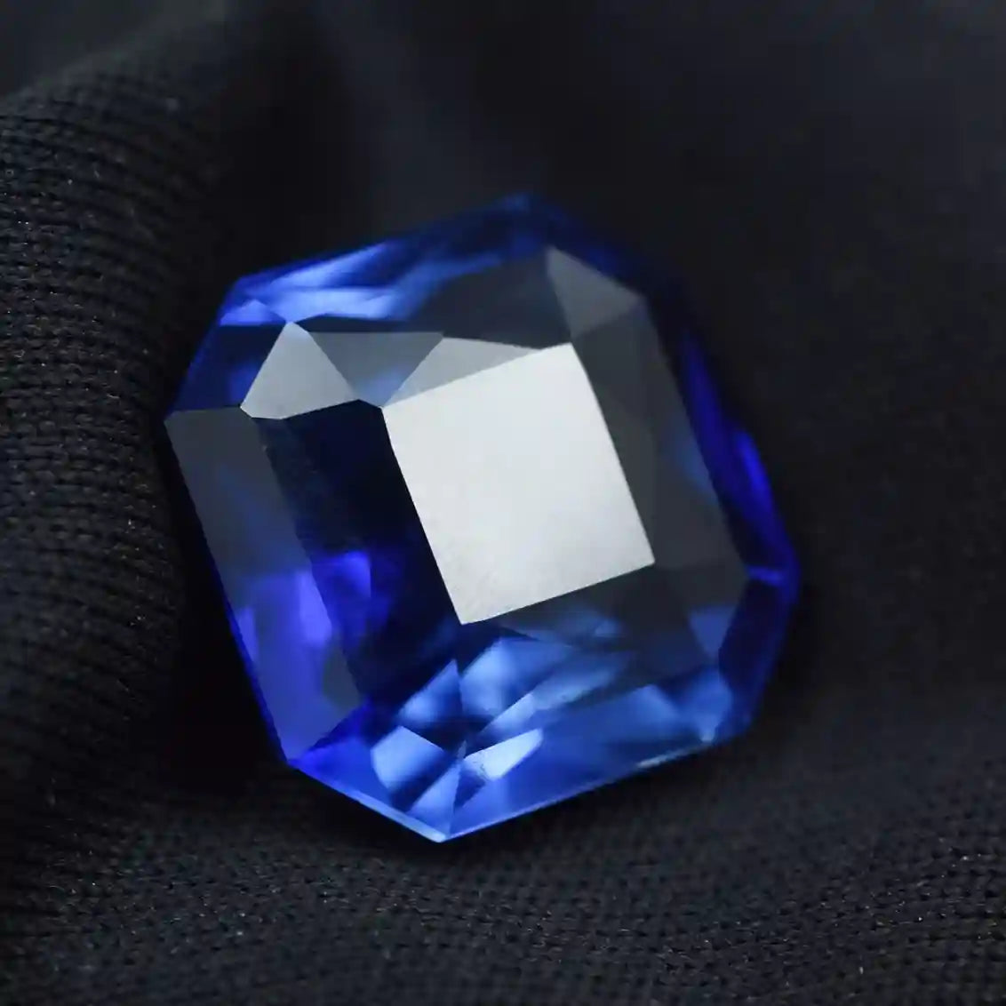 Blue gemstone on a black fabric background