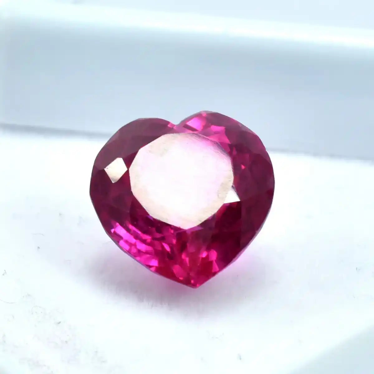 Heart-shaped red gemstone on a white background