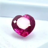 Heart-shaped red gemstone on a white background