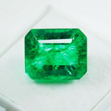 Untreated natural Colombian emerald cut gemstone, 7.65 carat, translucent green color on white background