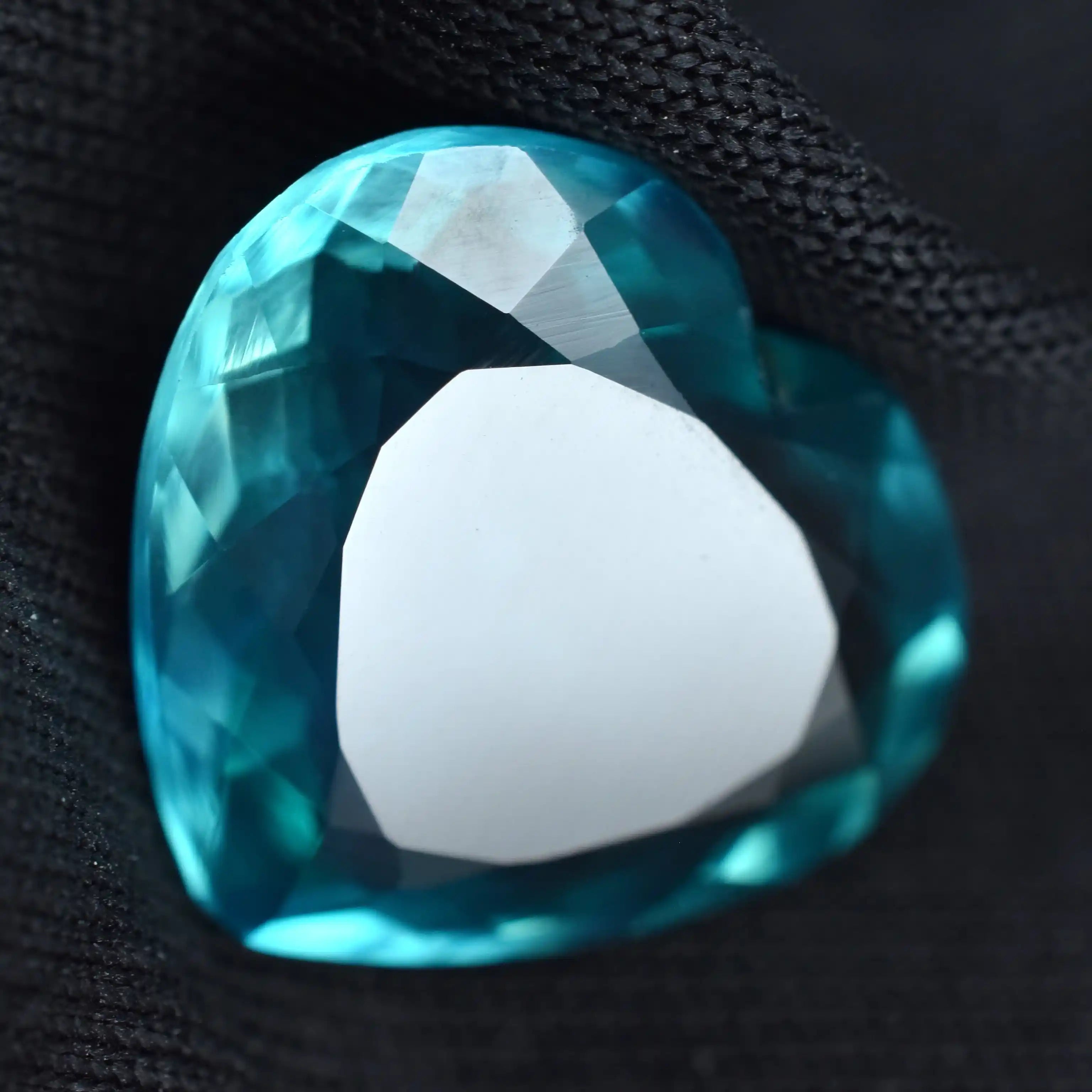 Close-up of a blue gemstone with a white stone in the center on a black background