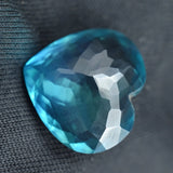 Faceted blue gemstone on a textured black background