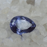 Natural Alexandrite gemstone centered among white rough stones highlighting color-change effect