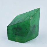 Natural green gemstone cube with uneven edge, deep color saturation.