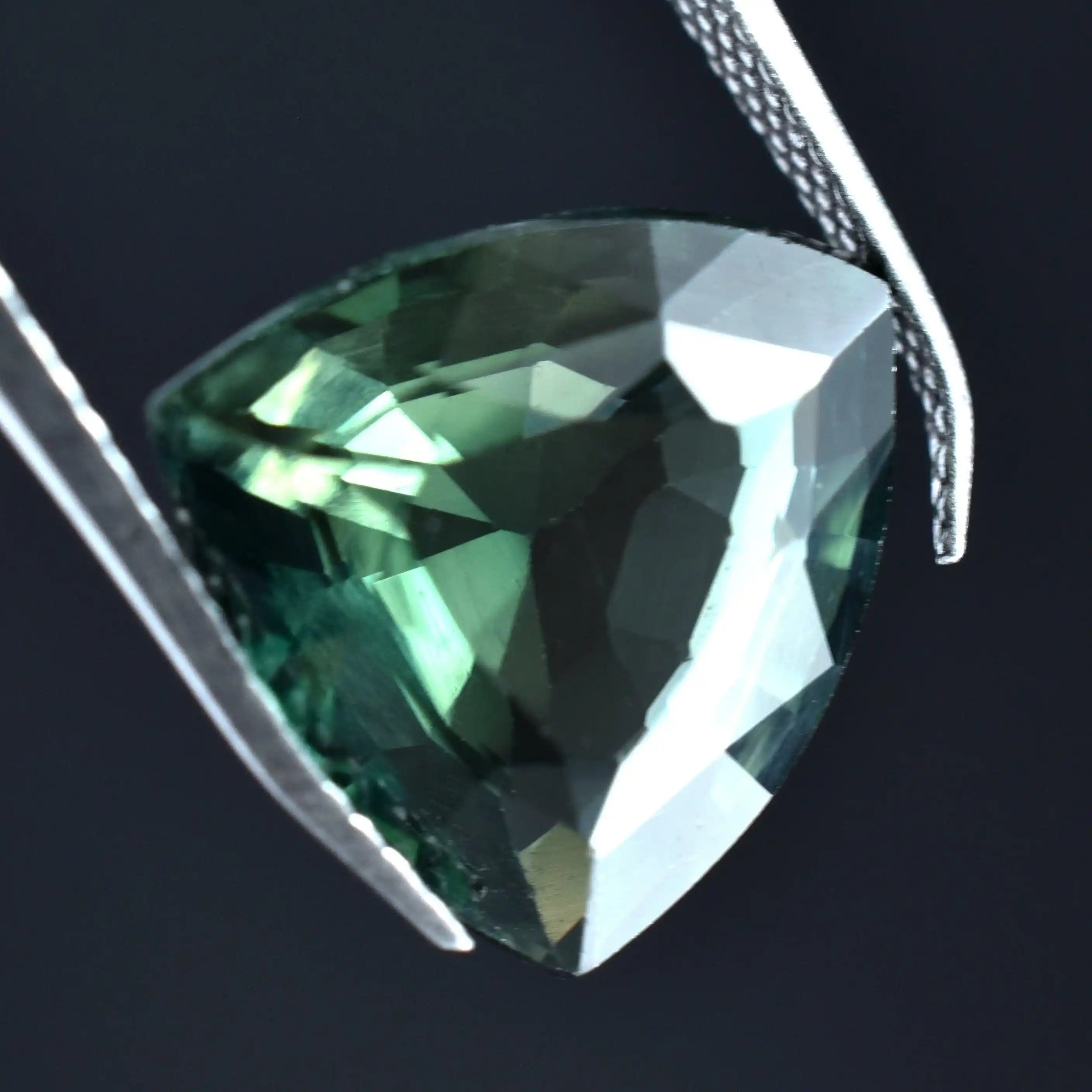 Green gemstone pendant on a dark background