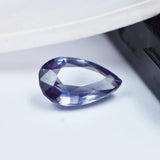Teardrop-shaped purple gemstone on a white background