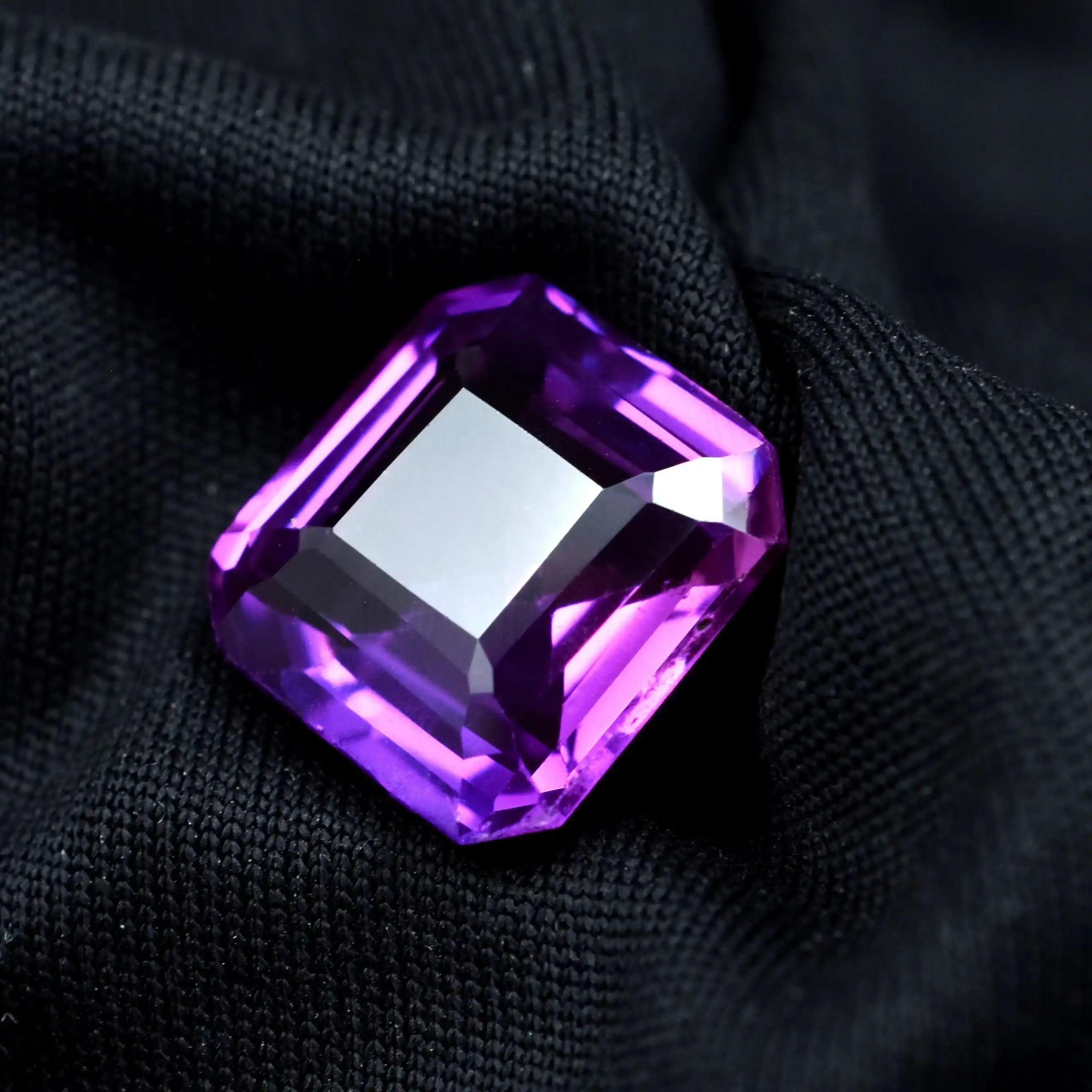 Purple gemstone on a black fabric background