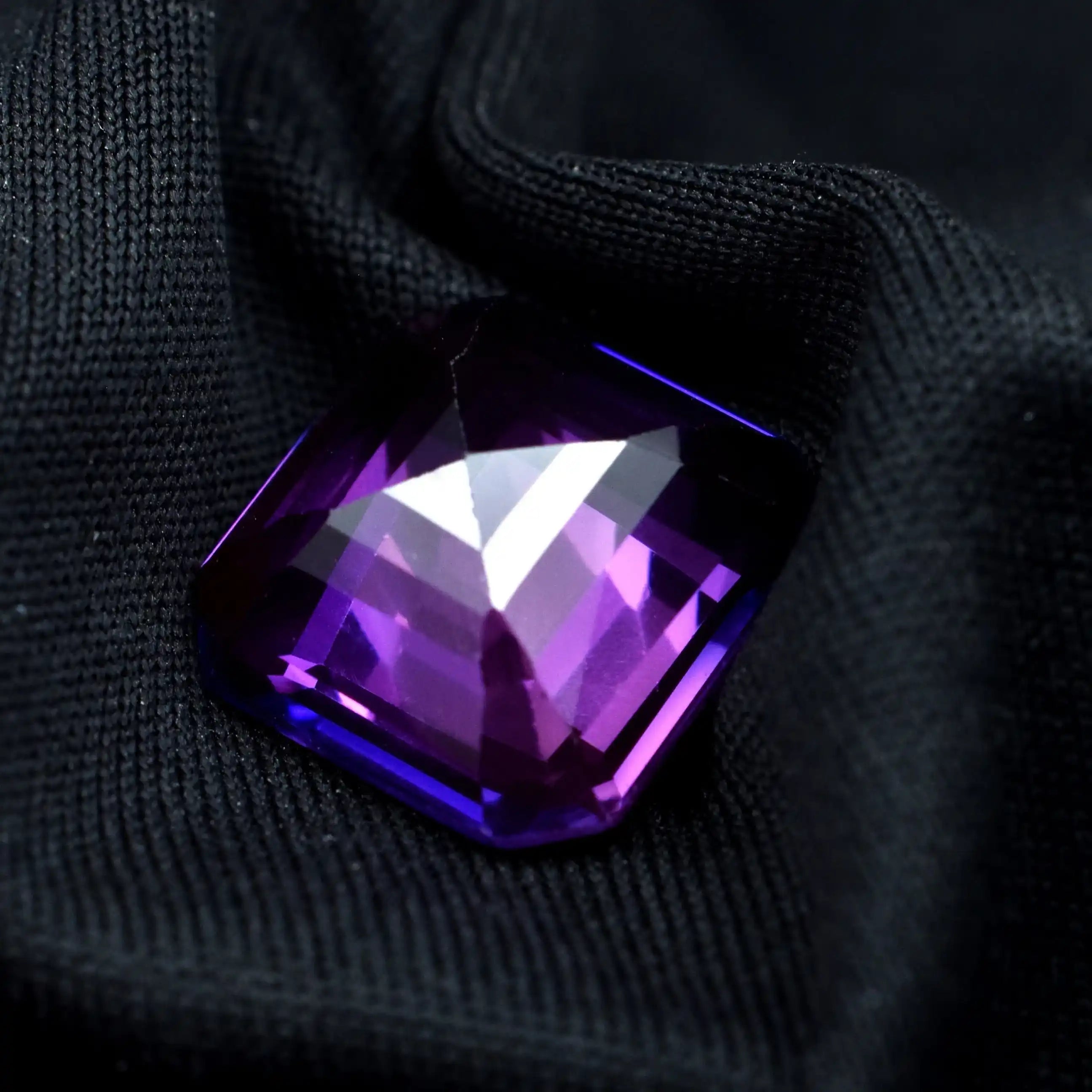 Purple gemstone on a black fabric background