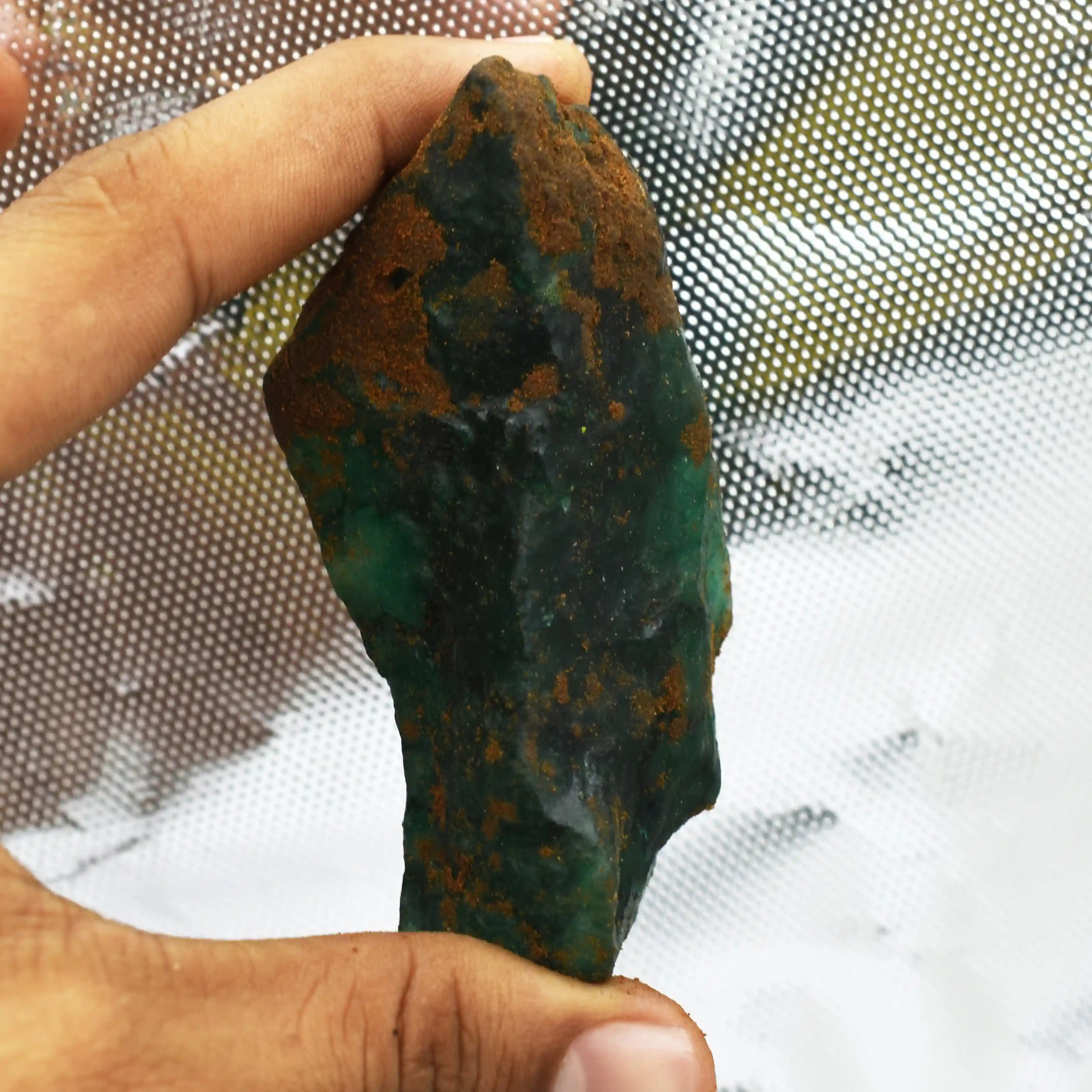 “Glowing green mineral specimen with natural dark matrix and rugged edges.”