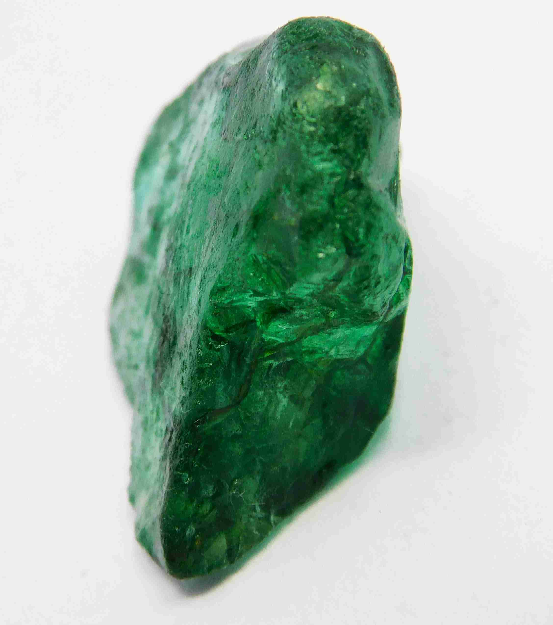 “Rough green crystal piece photographed close-up with glossy, uneven surfaces.”