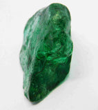 “Rough green crystal piece photographed close-up with glossy, uneven surfaces.”