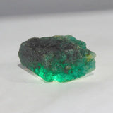 Close-up of large opaque green gem rough stone showcasing organic crystal structure and natural surface patterns.