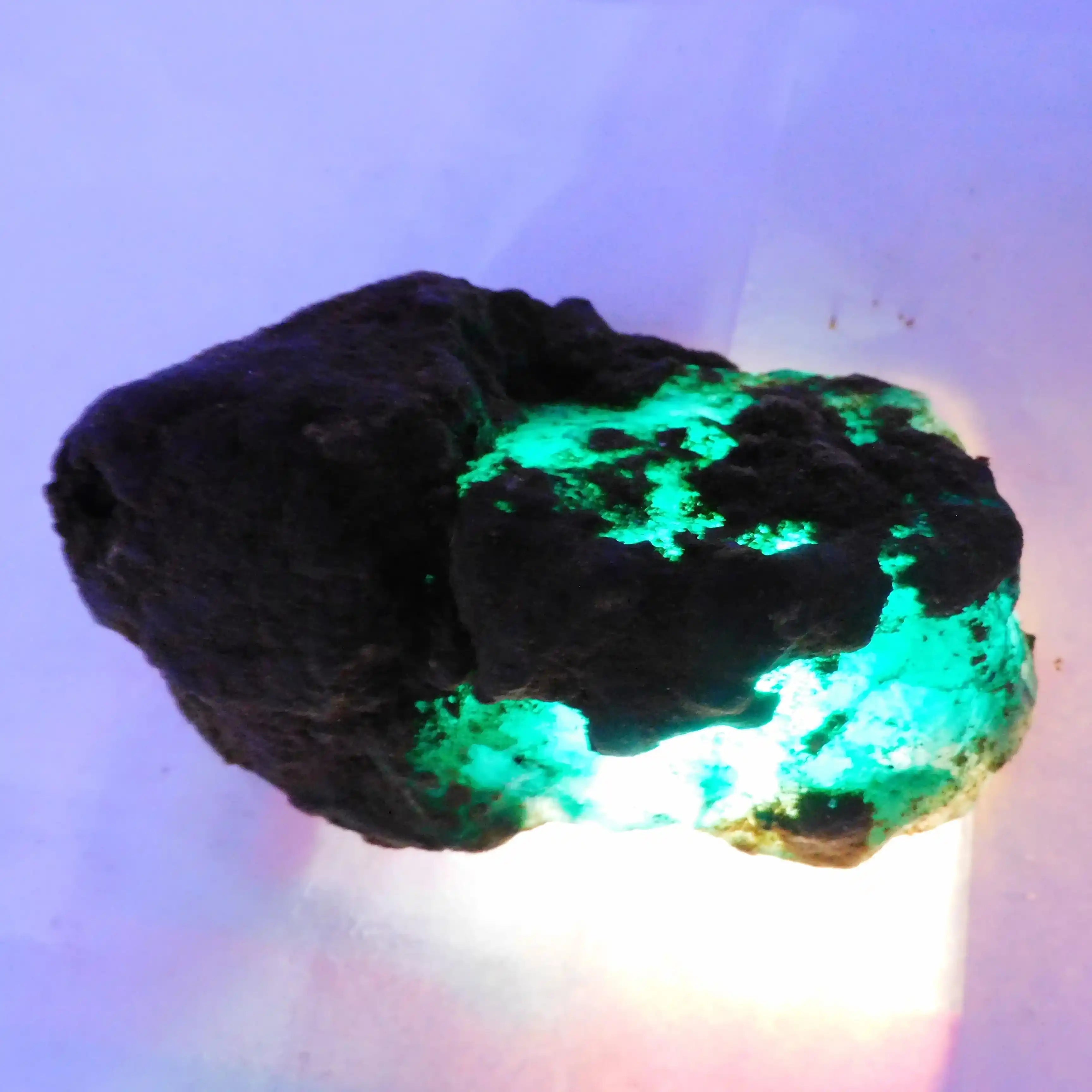 Mineral rock with green fluorescence on a white background