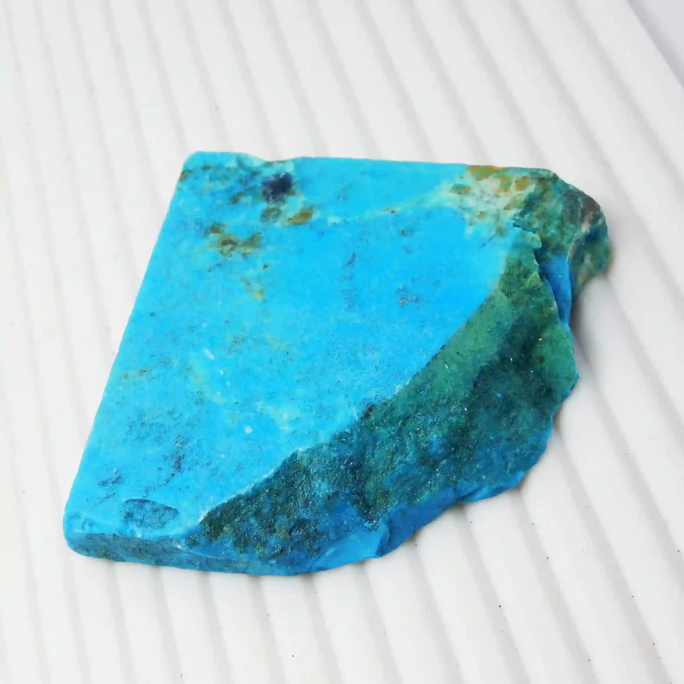 “Rough-cut turquoise gemstone showcasing vibrant blue color and earthy inclusions.”