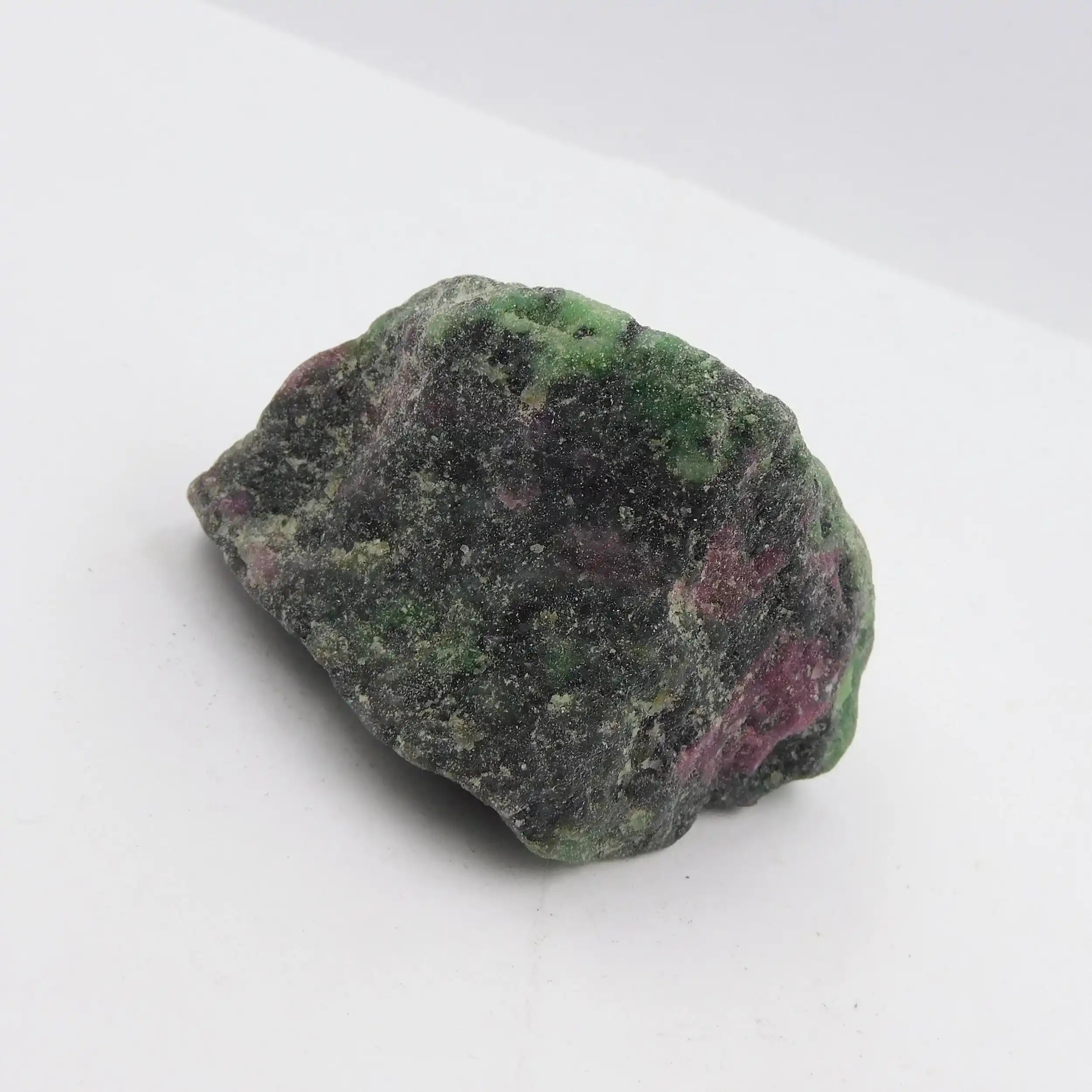 Raw green and pink stone on a white background