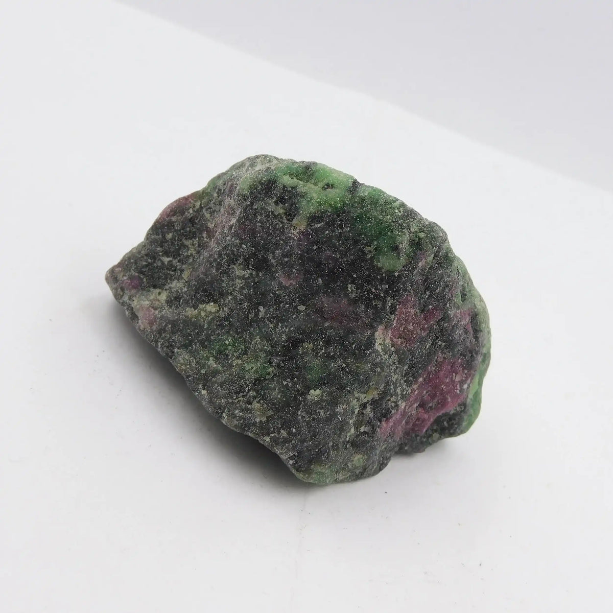 Raw green and pink stone on a white background