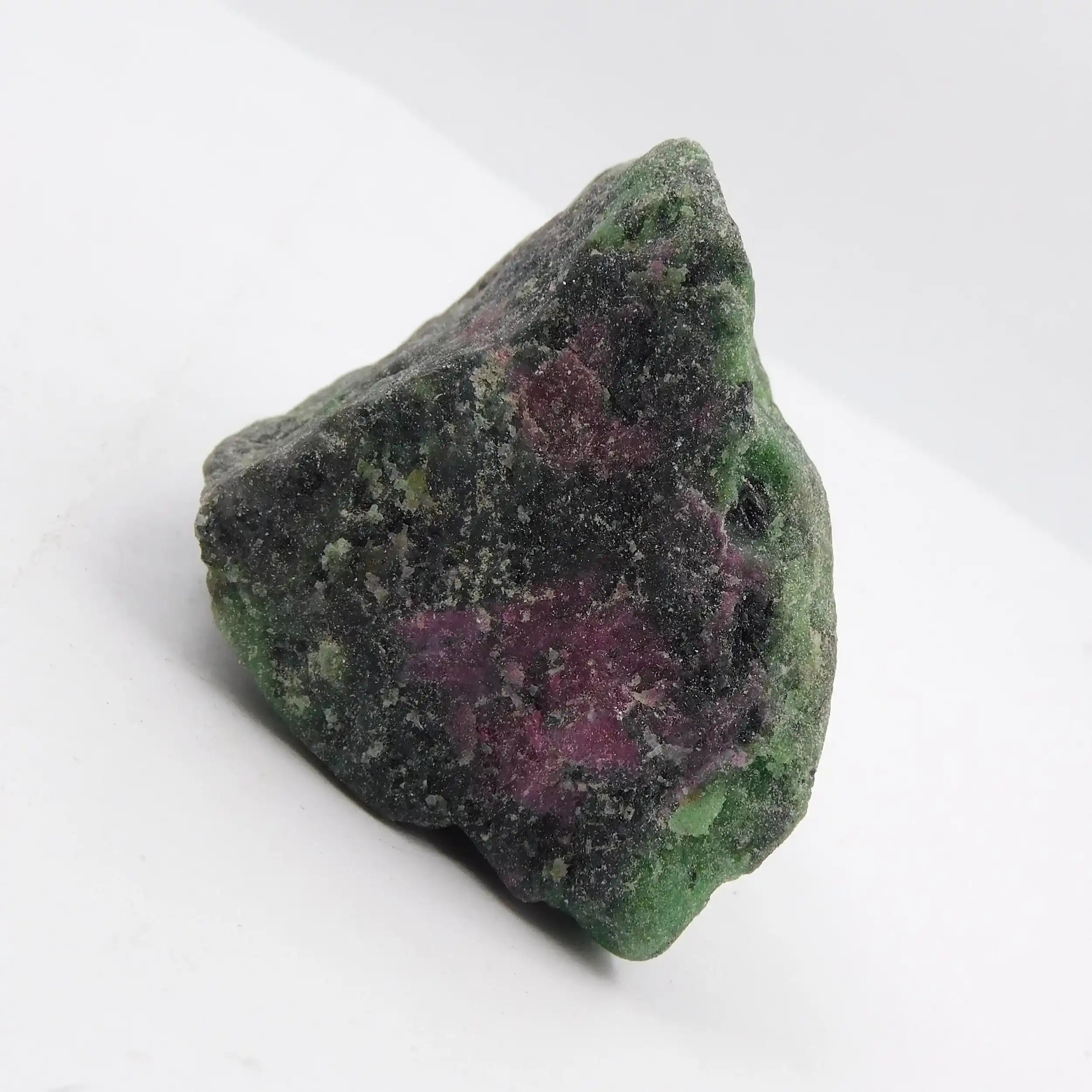 Mineral sample with green and purple colors on a white background