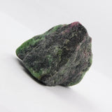 Raw green and purple stone on a white background